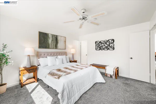 a spacious bedroom with a bed and a lamp