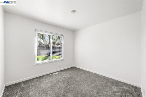 a view of a patio with table and chairs potted plants and floor to ceiling window and wooden fence