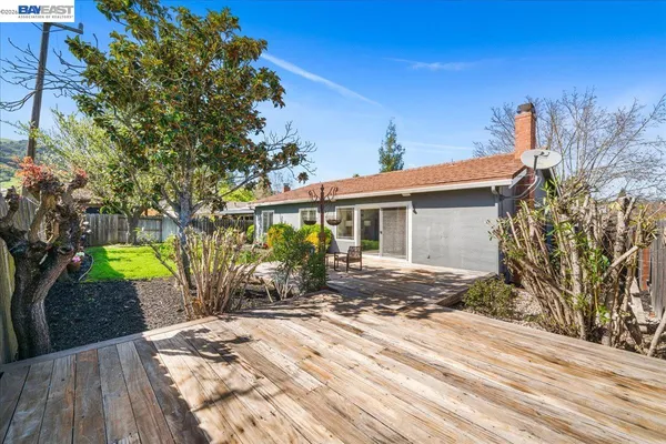 a view of backyard with tree and wooden fence