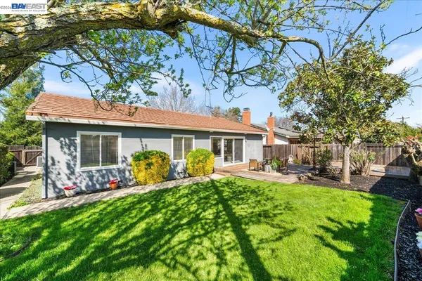 a view of a patio with table and chairs with wooden floor and fence
