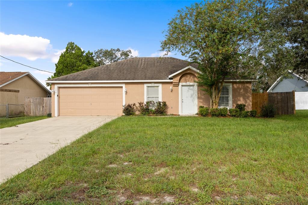 1009 Stratton Avenue Spring Hill, FL 34609 - Photo 1 of 29 a front view of a house with a garden and yard