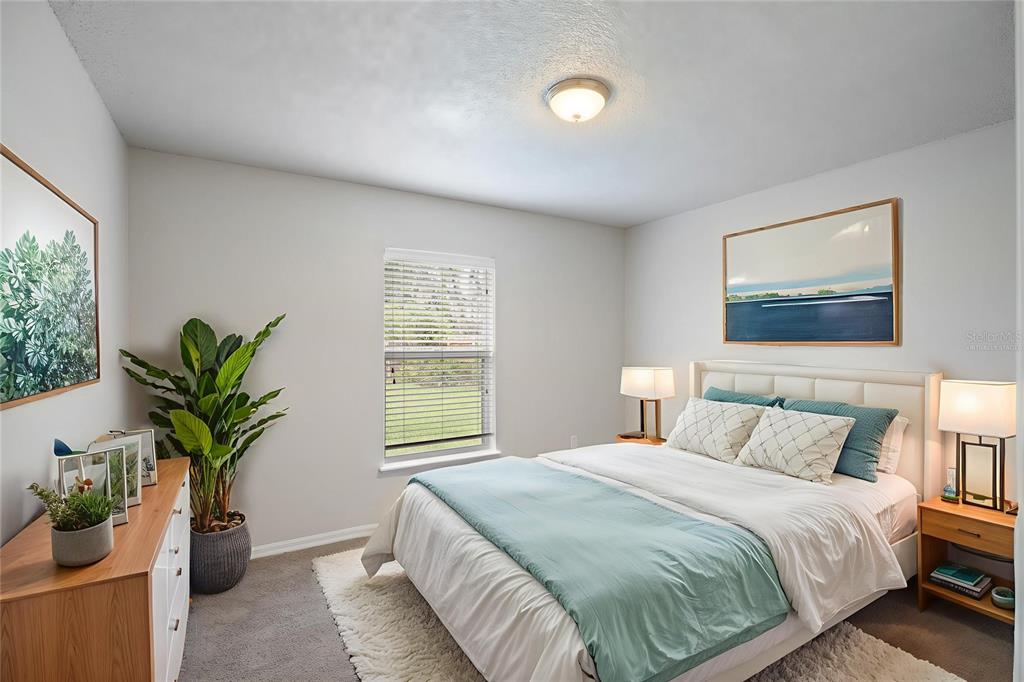 1009 Stratton Avenue Spring Hill, FL 34609 - Photo 11 of 29 a bedroom with a large bed and a potted plant