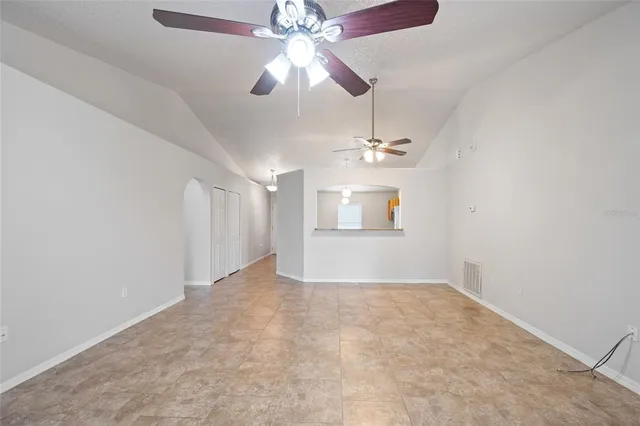 en empty room with ceiling fan and window
