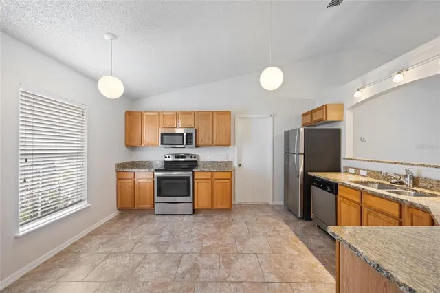a kitchen with a stove a sink and a refrigerator