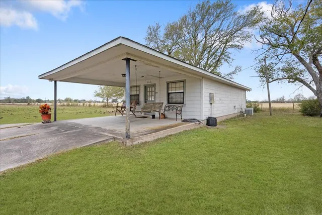a view of a house with a yard and a patio