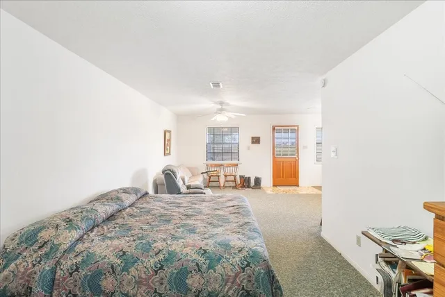 a large bedroom with a bed and wooden floor