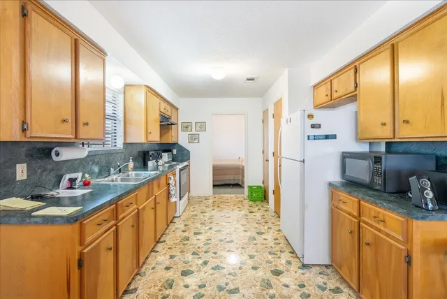 a kitchen with stainless steel appliances granite countertop a refrigerator and a stove