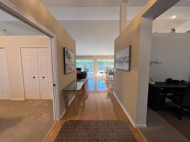a view of a hallway view with living room and wooden floor
