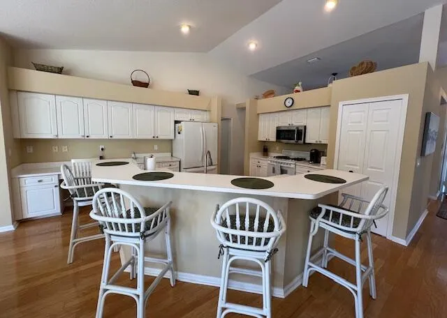 a dining room with stainless steel appliances granite countertop a table chairs and a refrigerator