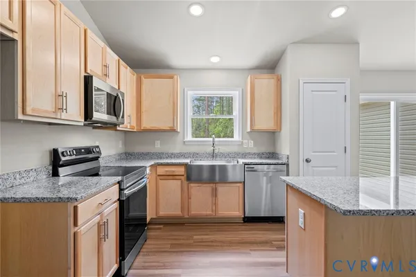 a kitchen with stainless steel appliances granite countertop a sink stove microwave and refrigerator