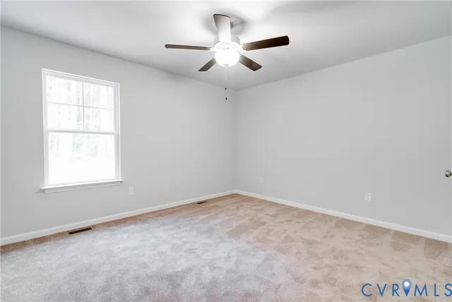 an empty room with a window and a ceiling fan