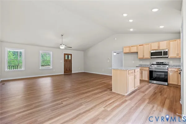 a view of a room with wooden floor and a kitchen