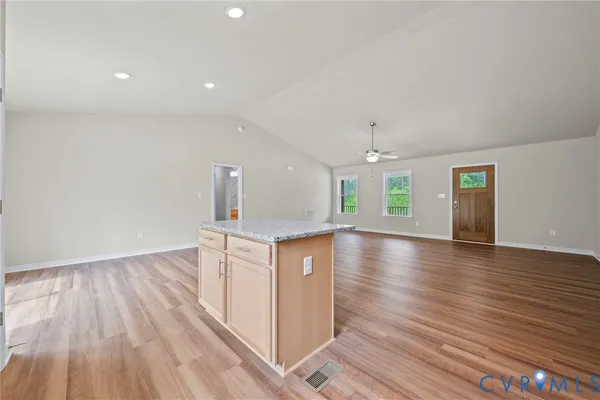 a kitchen with granite countertop wooden floors a stove and a refrigerator