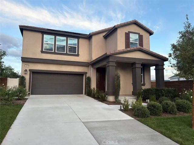 a front view of a house with yard and green space