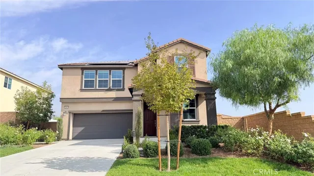 a front view of a house with a garden and plants