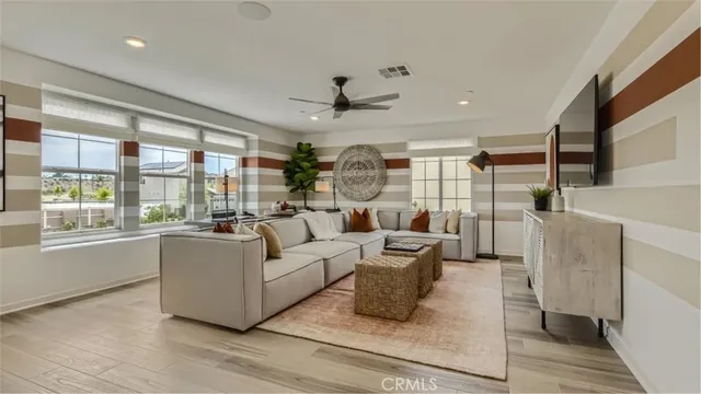 a living room with furniture large window and wooden floor
