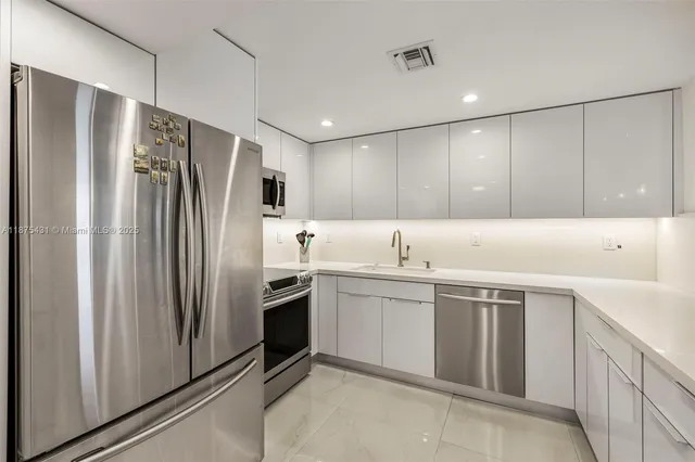 a kitchen with a sink stainless steel appliances and cabinets