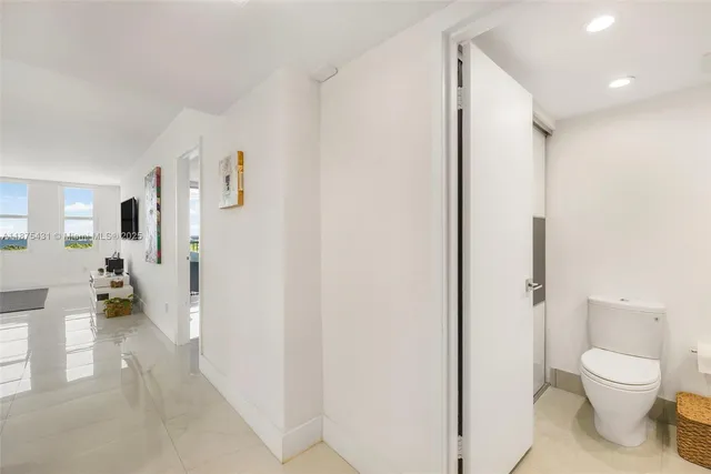 a bathroom with a toilet a sink and a large mirror