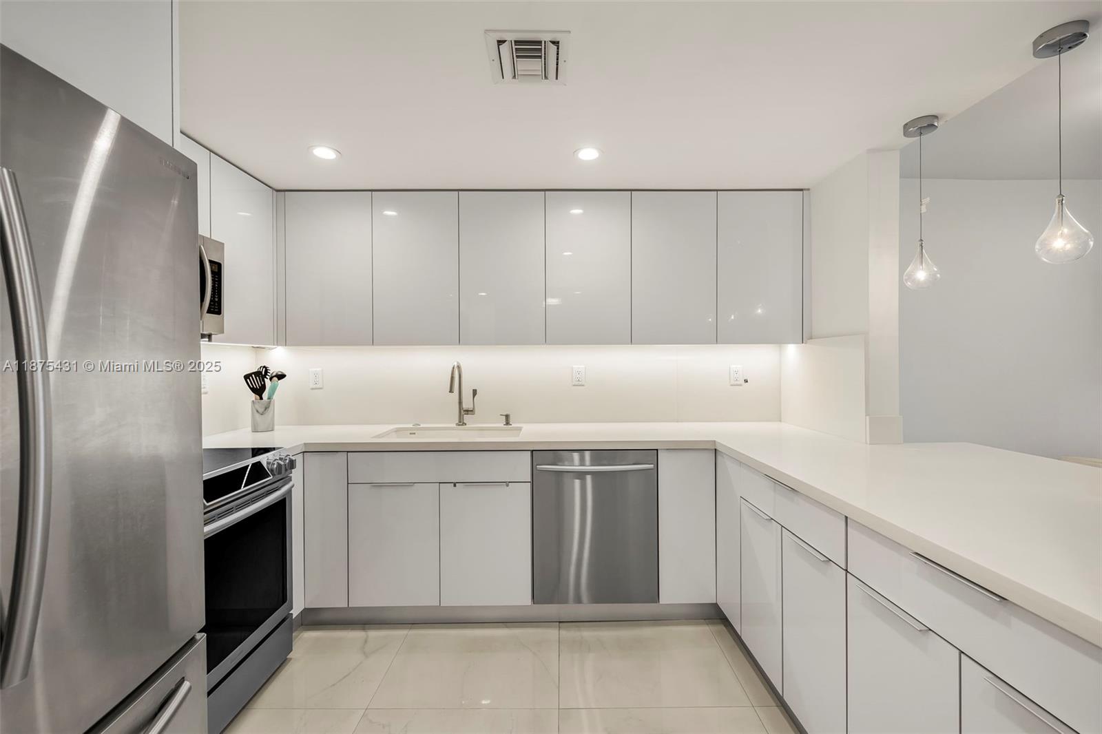 5401 Collins Avenue, Unit 1231 Miami Beach, FL 33140 - Photo 18 of 43 a kitchen with a sink stainless steel appliances and cabinets