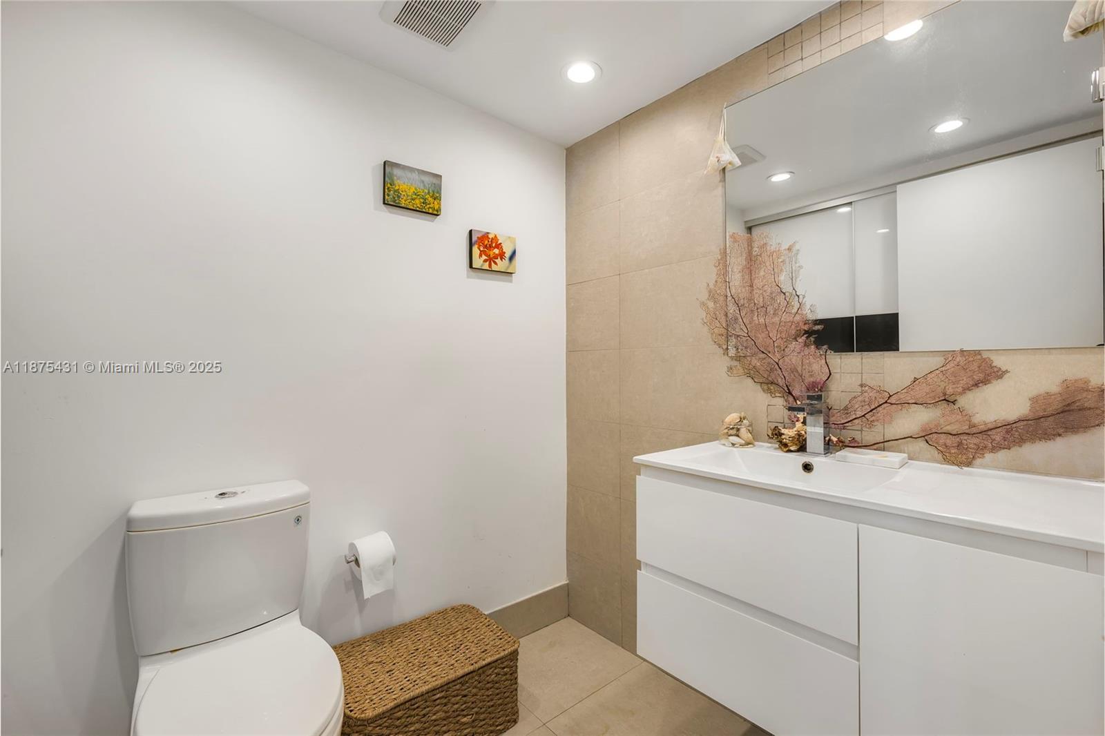 5401 Collins Avenue, Unit 1231 Miami Beach, FL 33140 - Photo 22 of 43 a bathroom with a toilet sink and mirror