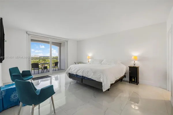 a bedroom with a bed a tv and wooden floor