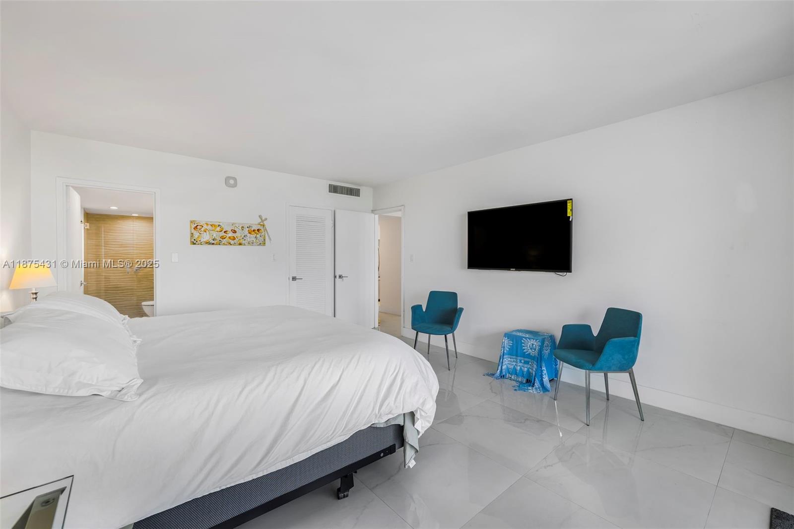 5401 Collins Avenue, Unit 1231 Miami Beach, FL 33140 - Photo 27 of 43 a bedroom with a bed a tv and wooden floor