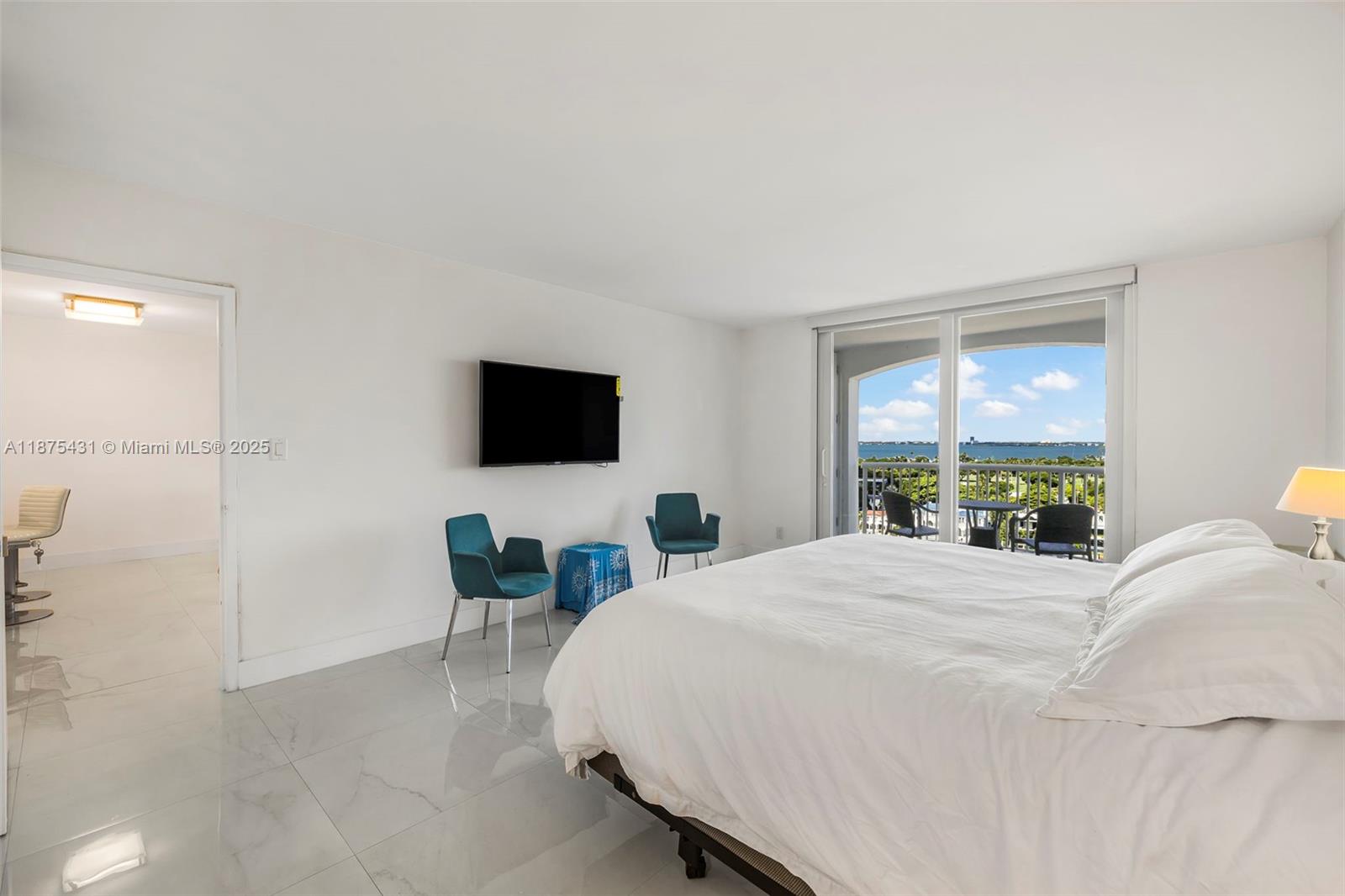 5401 Collins Avenue, Unit 1231 Miami Beach, FL 33140 - Photo 28 of 43 a bedroom with a bed a large window and a flat screen tv