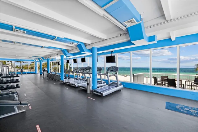 a room with gym equipment and large windows