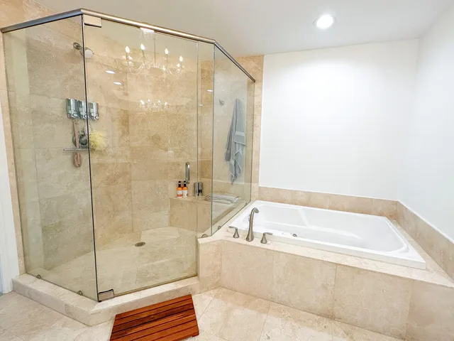 a bathroom with a granite countertop sink a large mirror and a bathtub