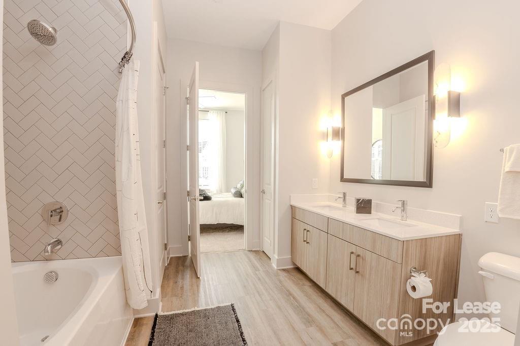 3110 Doe River Way, Unit CHADWICK Matthews, NC 28105 - Photo 43 of 48 a bathroom with a double vanity sink a mirror and a bathtub