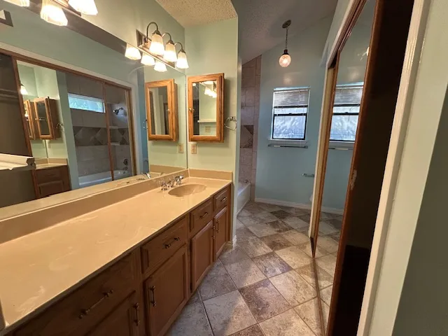 a spacious bathroom with a granite countertop sink a mirror and a shower