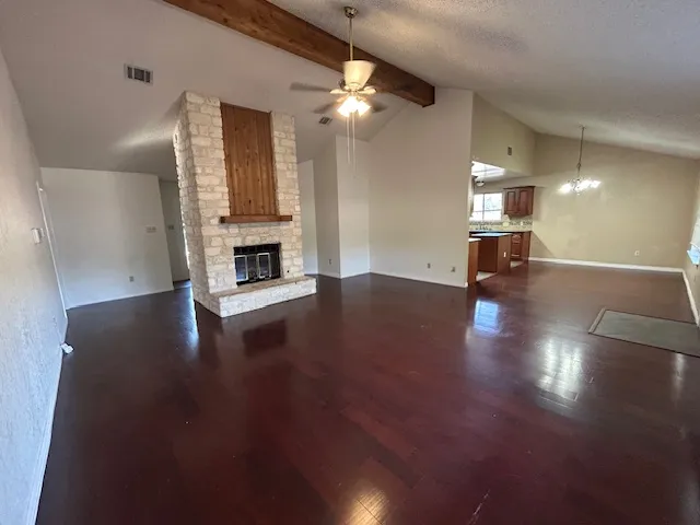 a view of a livingroom with wooden floor a ceiling fan and windows