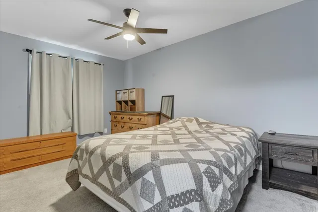 a bedroom with a bed and a ceiling fan