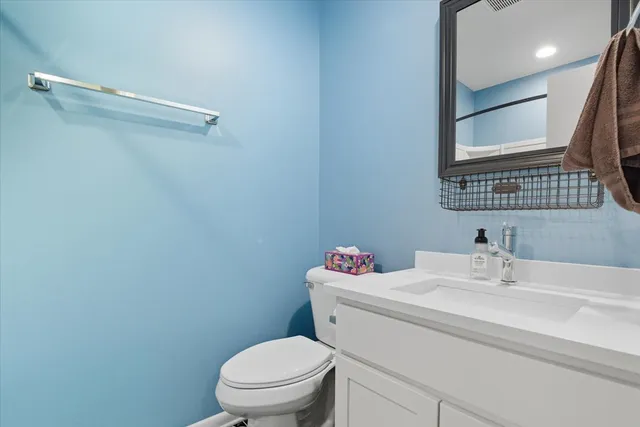 a bathroom with a sink mirror vanity and toilet
