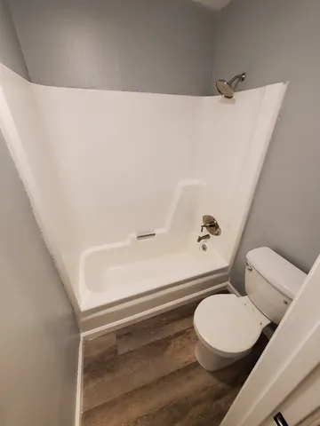 an empty room with wooden floor and a window