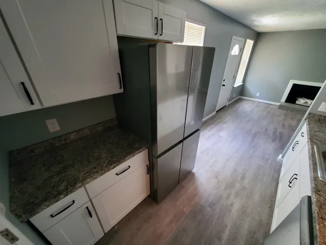 a kitchen with granite countertop a refrigerator and a stove