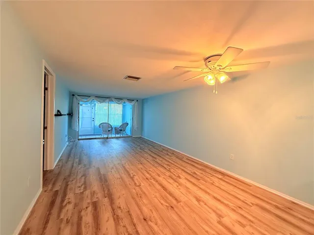 a view of empty room with wooden floor