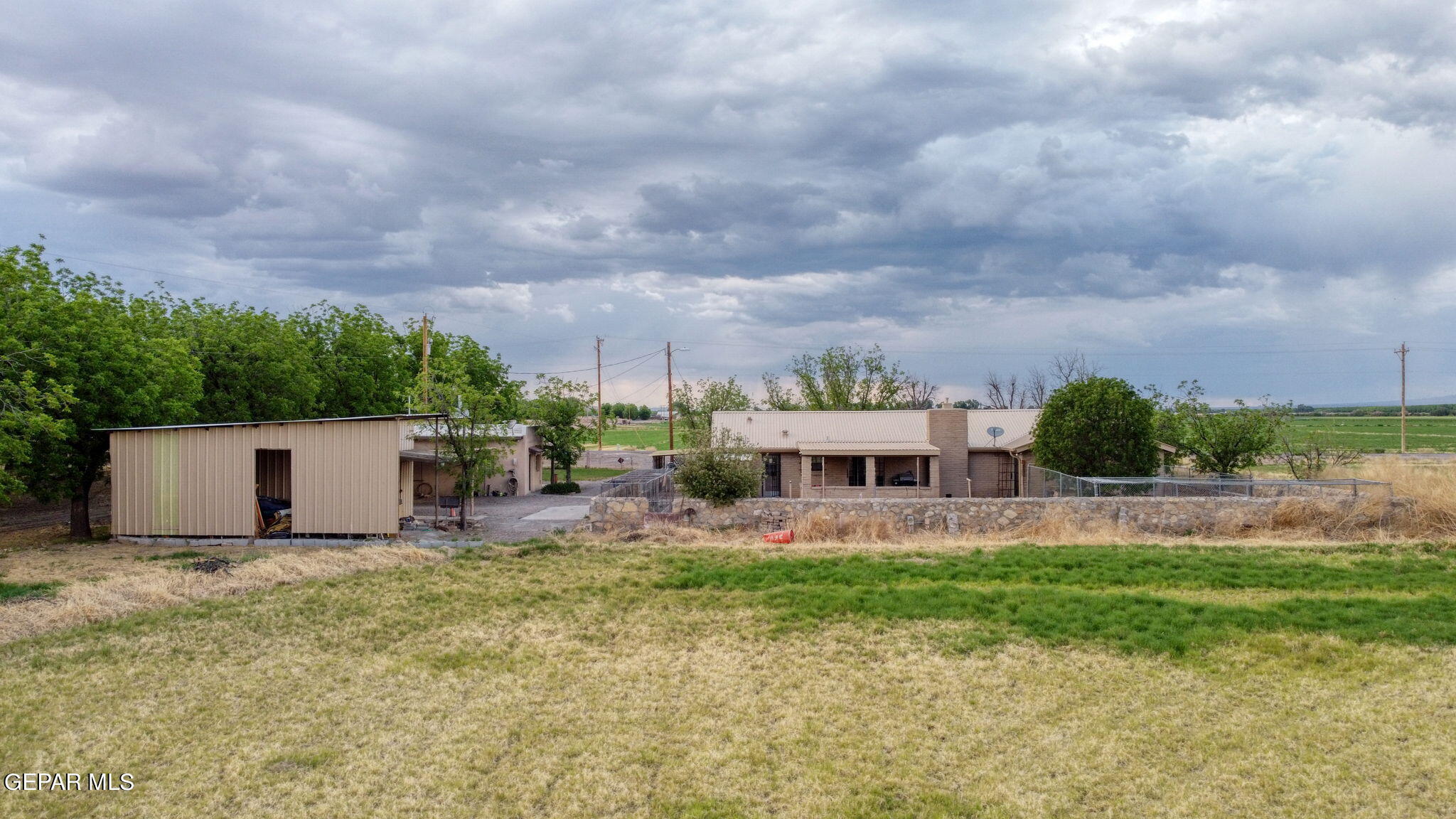 3025-3035 West O'Hara Road Anthony, NM 88021 - Photo 33 of 41 a view of a white house with a big yard and plants