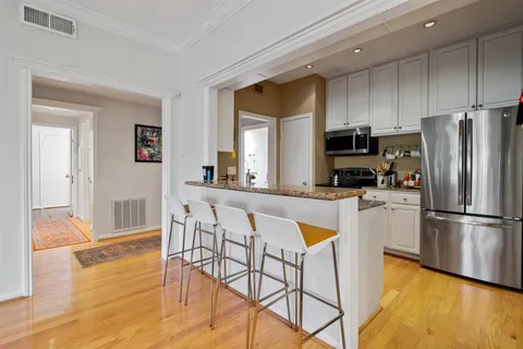 a kitchen with stainless steel appliances a refrigerator a stove top oven and a center island