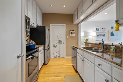 a large kitchen with a sink and stainless steel appliances