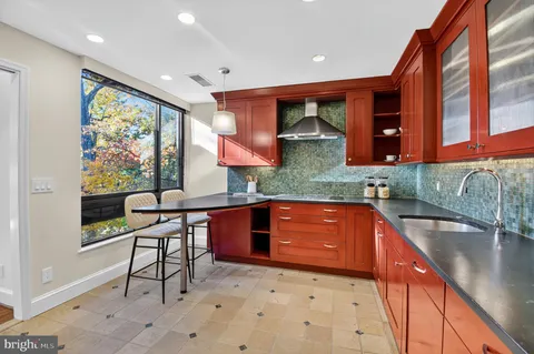 a kitchen with stainless steel appliances granite countertop sink stove and cabinets
