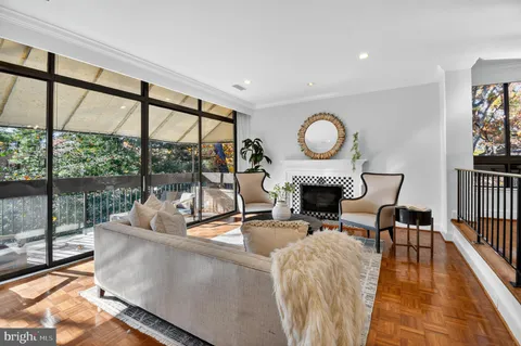a living room with furniture a fireplace and a floor to ceiling window