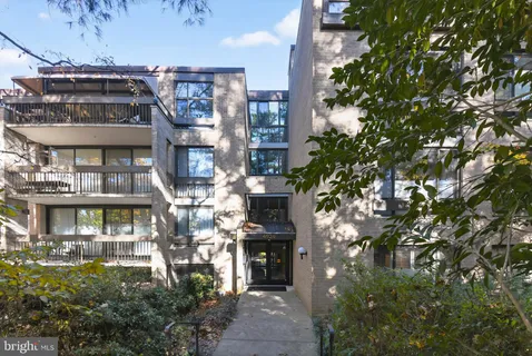 a front view of a multi story building with yard