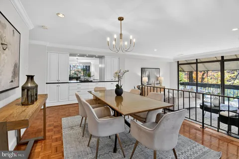 a dining room with wooden floor a chandelier a glass table and chairs