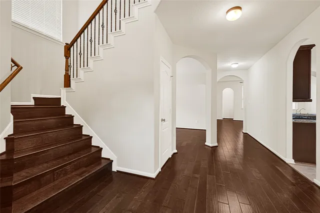 a view of a big room with wooden floor and a ceiling fan