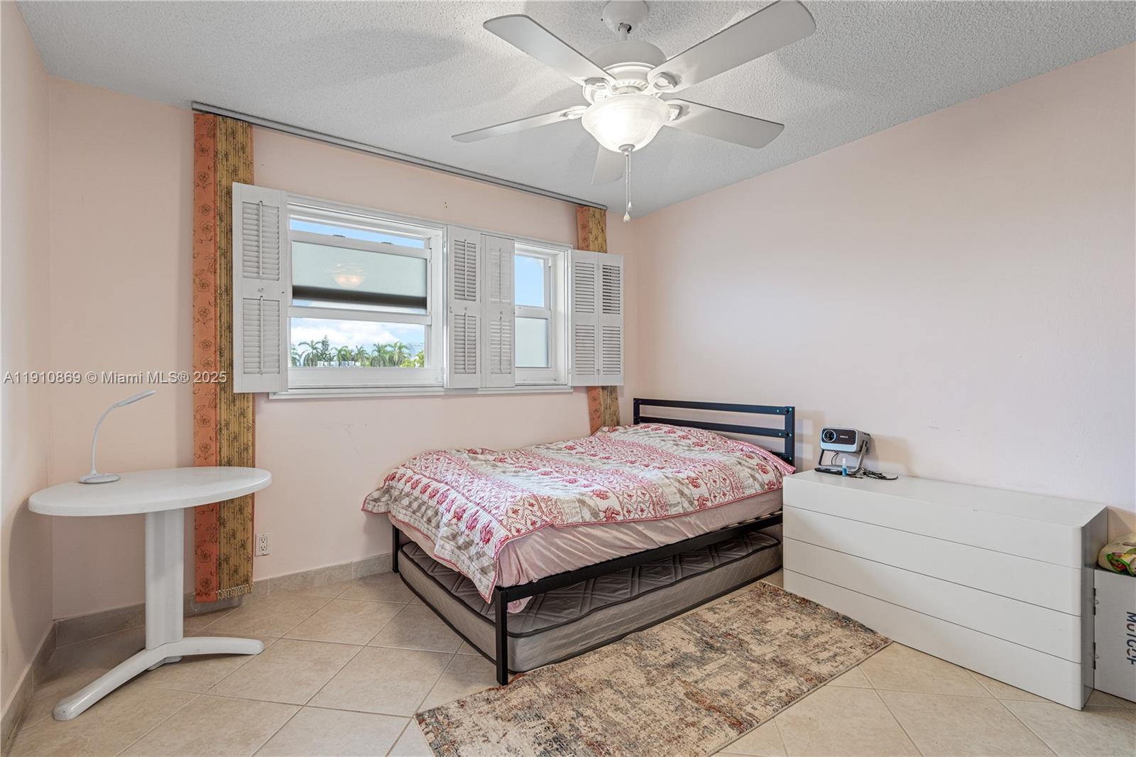 1425 Atlantic Shores Boulevard, Unit 409 Hallandale Beach, FL 33009 - Photo 14 of 30 a bedroom with a bed and a table with chair