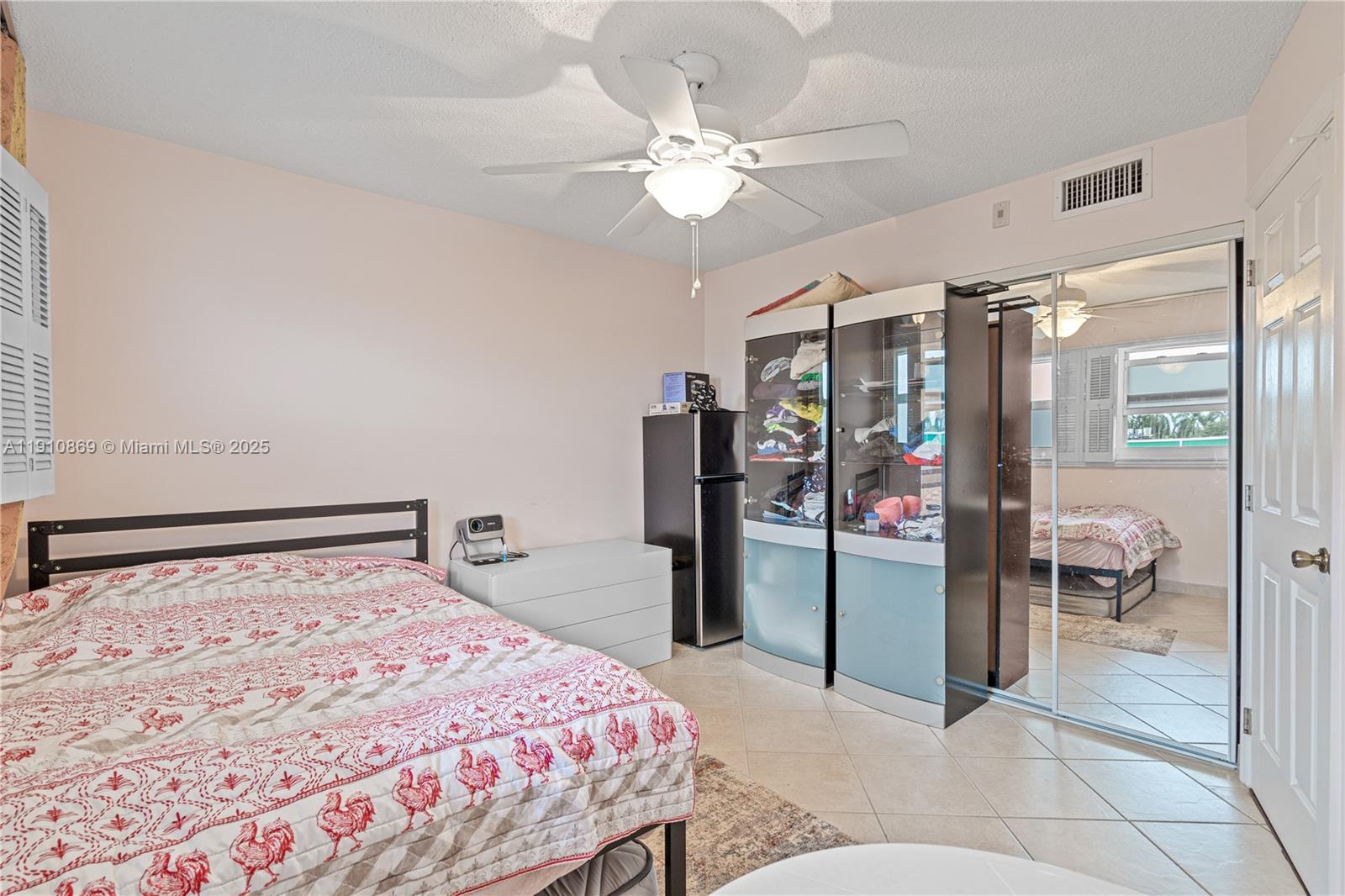 1425 Atlantic Shores Boulevard, Unit 409 Hallandale Beach, FL 33009 - Photo 15 of 30 a bedroom with a large bed and a chandelier