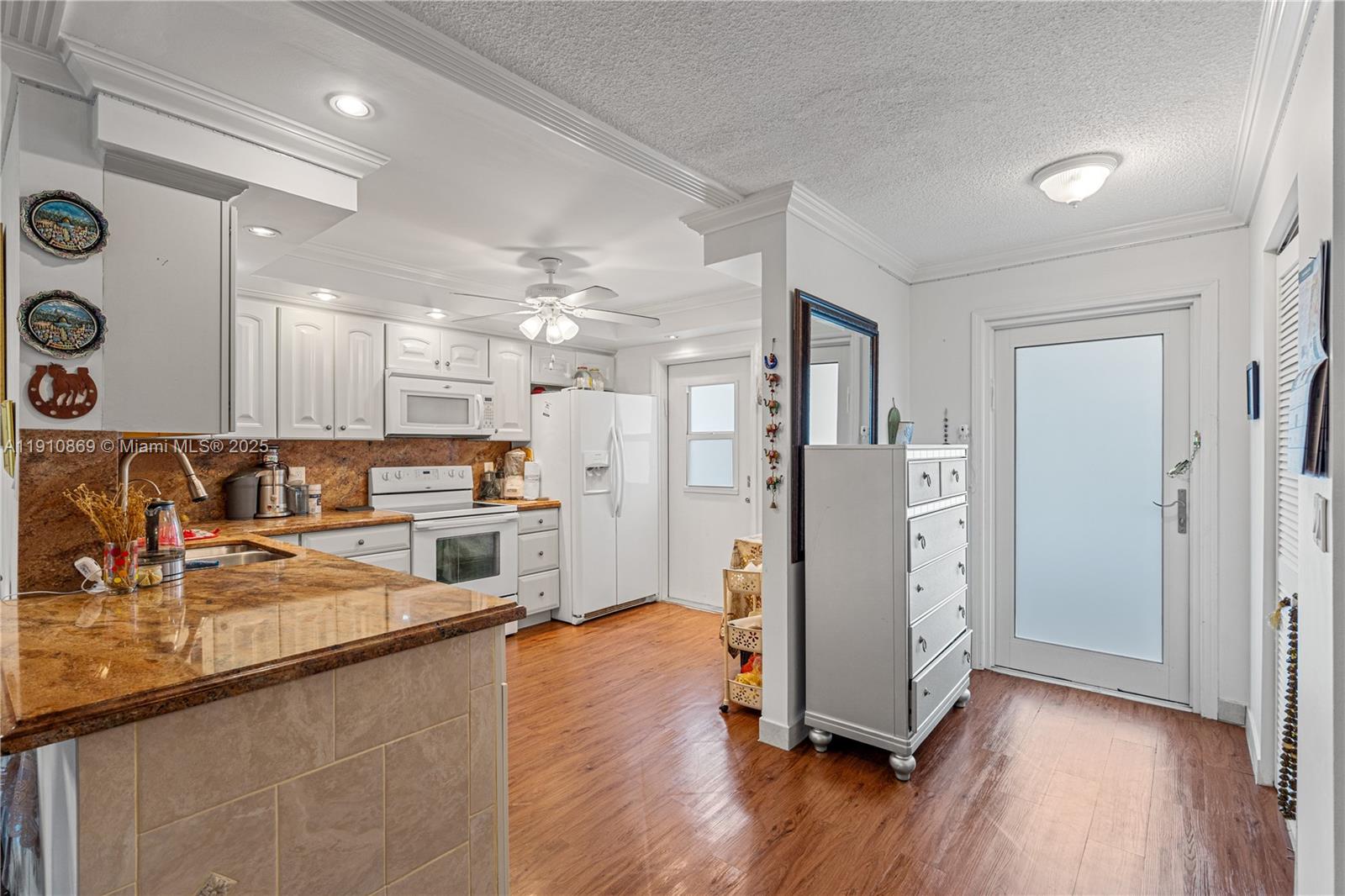 1425 Atlantic Shores Boulevard, Unit 409 Hallandale Beach, FL 33009 - Photo 5 of 30 a kitchen with stainless steel appliances granite countertop a refrigerator a sink a stove and white cabinets with wooden floor