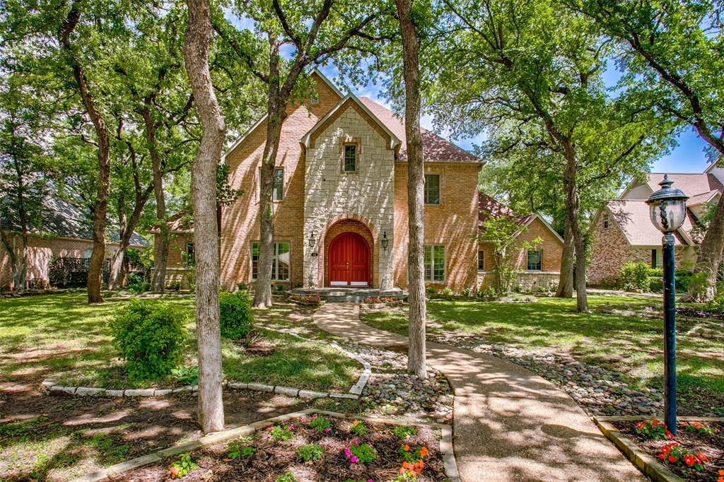 a view of a yard in front of a house with a large tree