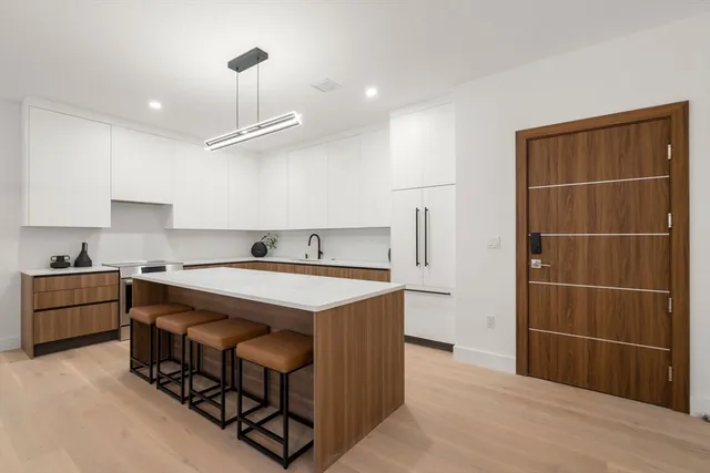 a kitchen that has a sink a stove and a refrigerator